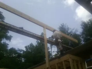 Carpenter setting a ridge beam over a new addition frame — Ice Dam Removal by Roofing Brothers in Owenton