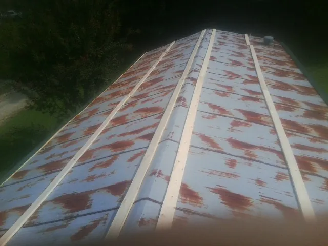 Rusted metal roof panels with new wood purlins before replacement — Storm Damage Roof Repair in Owenton by Roofing Brothers