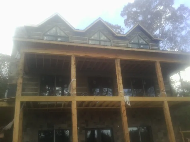 Dormers and porch framing on a large log home under construction — Roof Coating work by our crew in Owenton