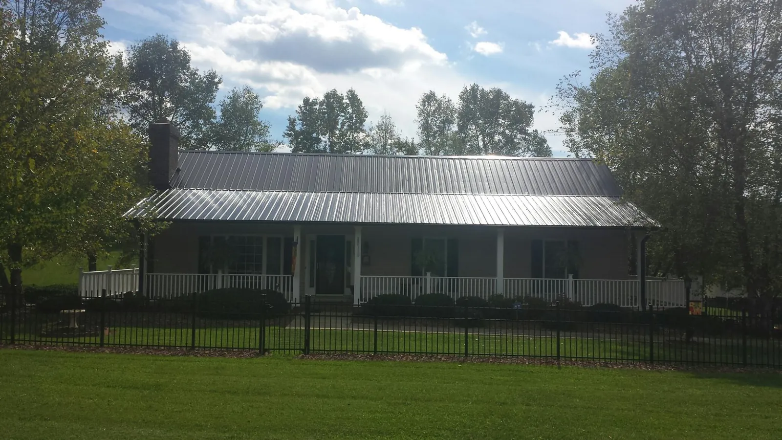Gray metal roof on a brick ranch with a full width front porch — Gutter Guard Installation work by our crew in Owenton